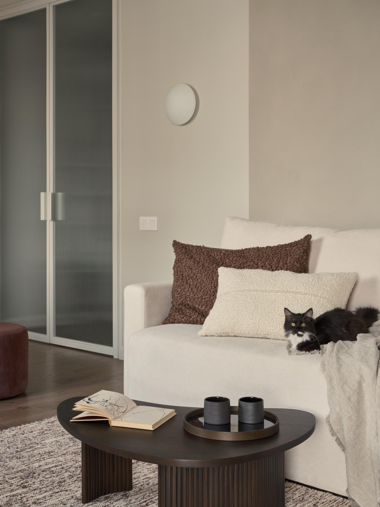 Чтобы разграничить рабочую зону в гостиной от диванной, дизайнер акцентировала основное внимание на цвете и фактуре. Стены и потолок в рабочей части комнаты выполнены в более светлых молочно-бежевых тонах.