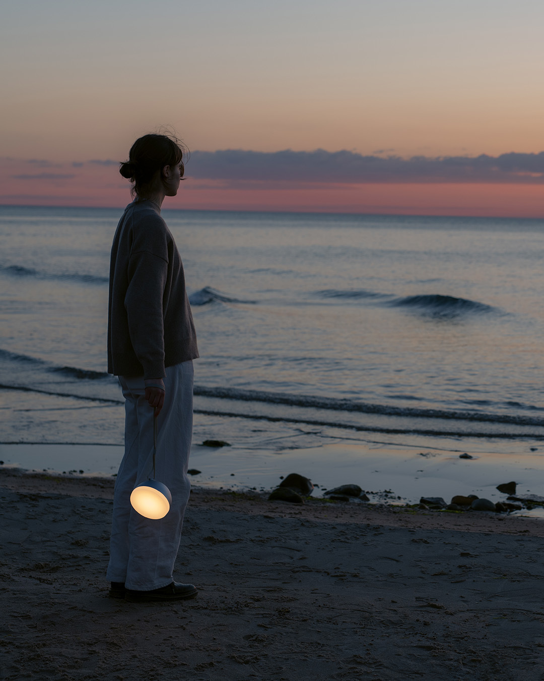 Девушка с портативным светильником New Works Sphere Adventure Light в руке